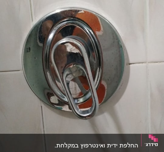 ברז מים כרום על קיר אריחים לבנים